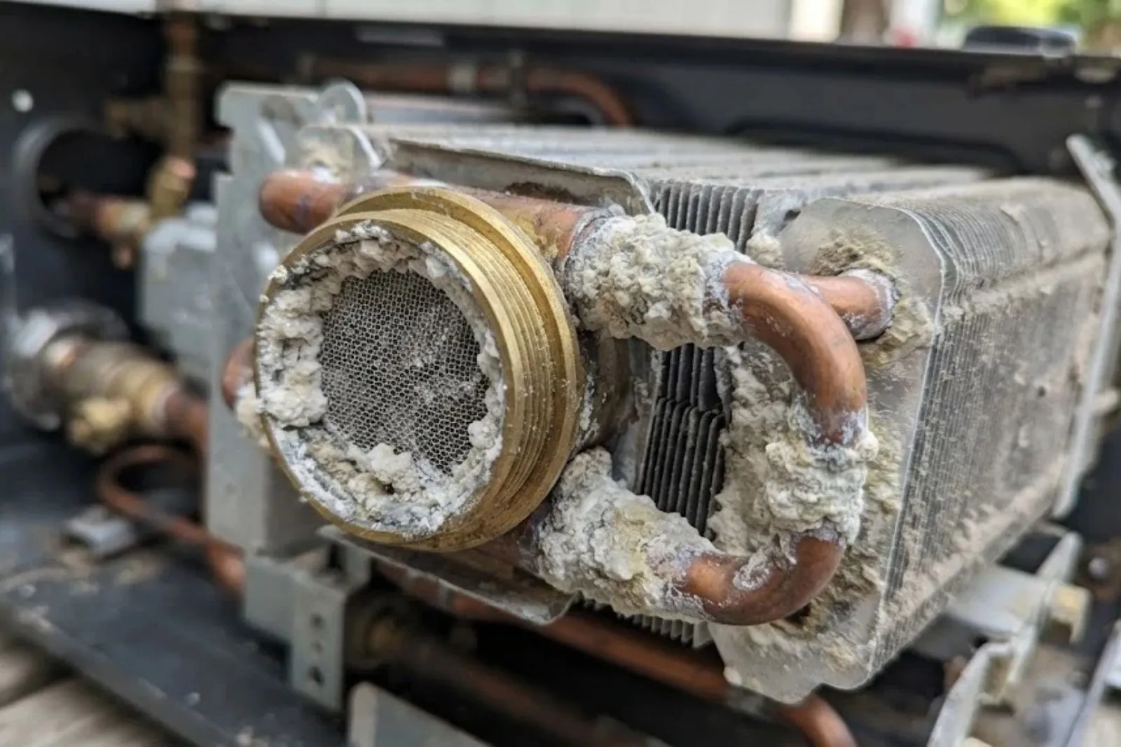 Mineral scale on a tankless water heater part from Englewood water